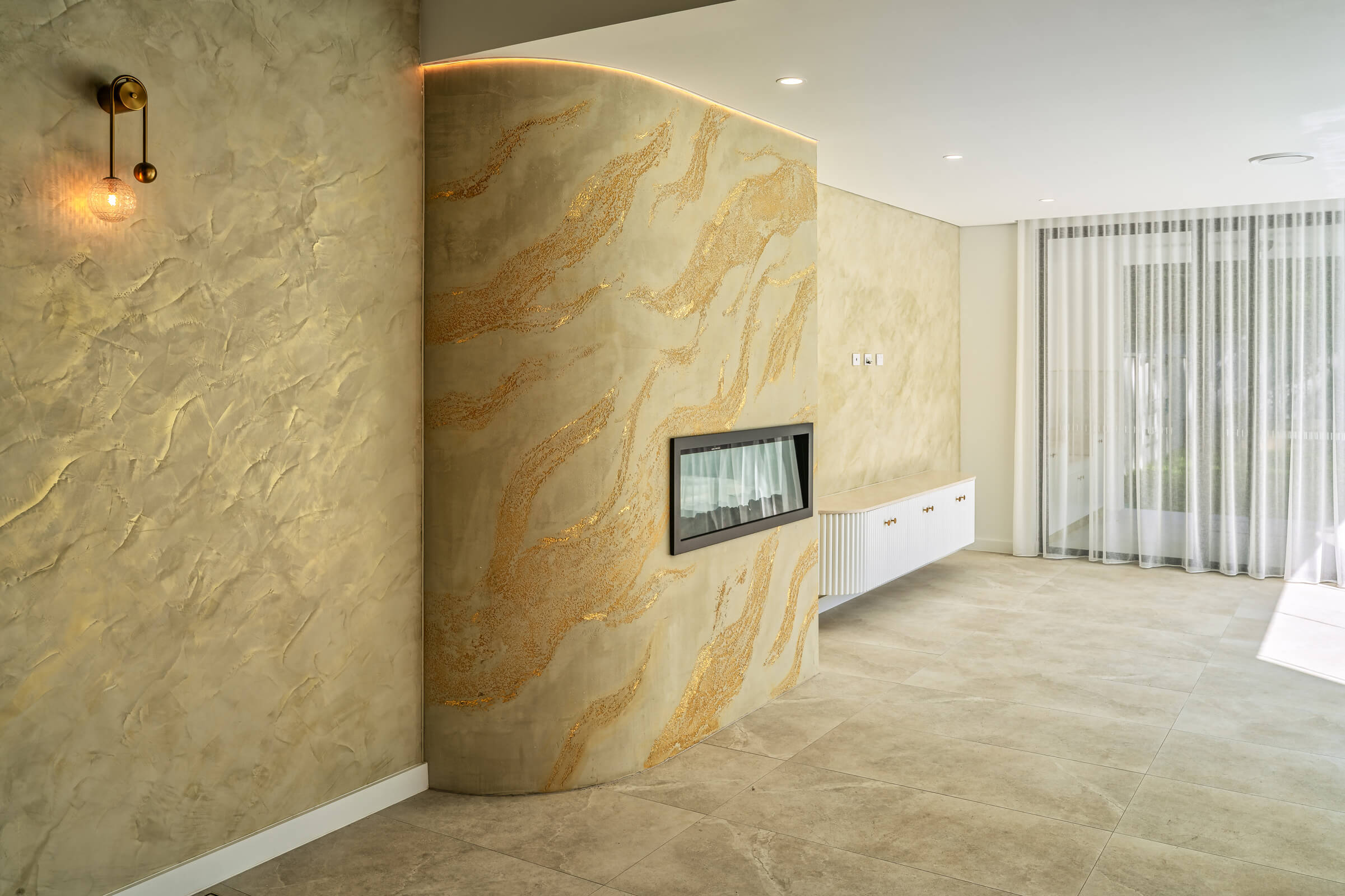 Figure 2 - Walls in Venetian plaster with gold wax and Fireplace in Split Stone technique with gold flakes – Project code WS0314 (Peakhurst - NSW) From Mud to Microcement: The Evolution of Rendering